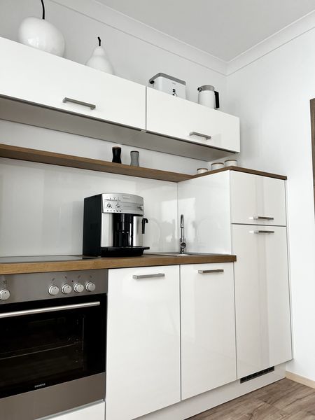 weiße Schränke in der Küche der Ferienwohnung mit Toaster und Wasserkocher