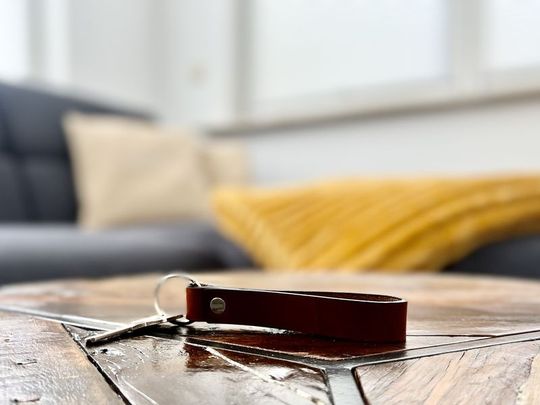 Wohnungsschlüssel auf Holztisch vor dem Sofa