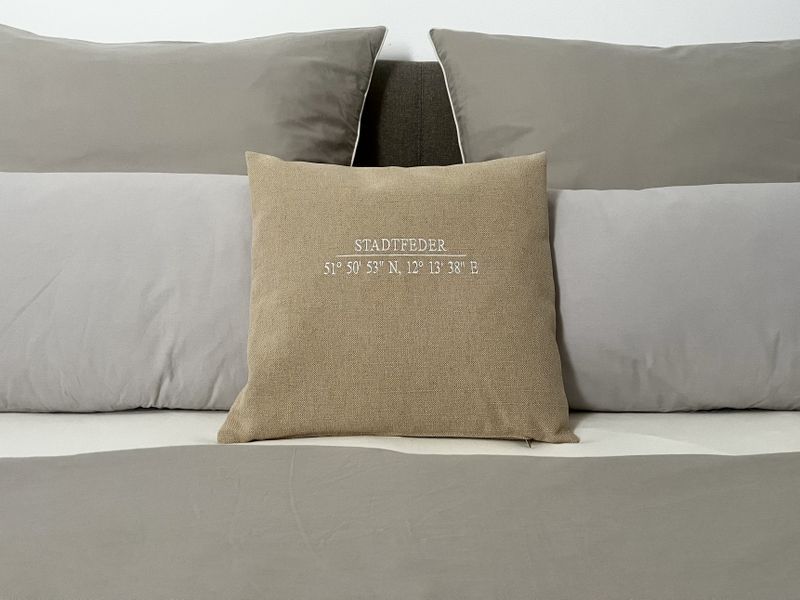Dekokissen mit Ortskennung auf dem Doppelbett im Schlafzimmer der Ferienwohnung