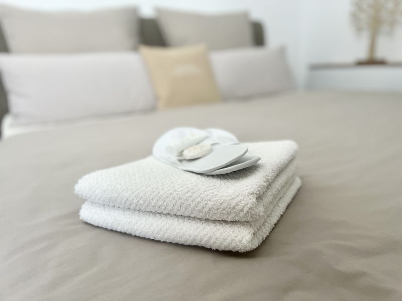 gefaltete Handtücher auf dem Bett im Schlafzimmer für Urlaubsgäste
