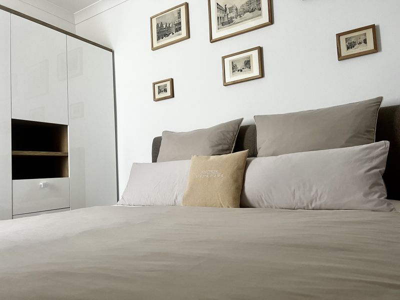 Gemütliches Doppelbett mit beigen Kissen in der Ferienunterkunft