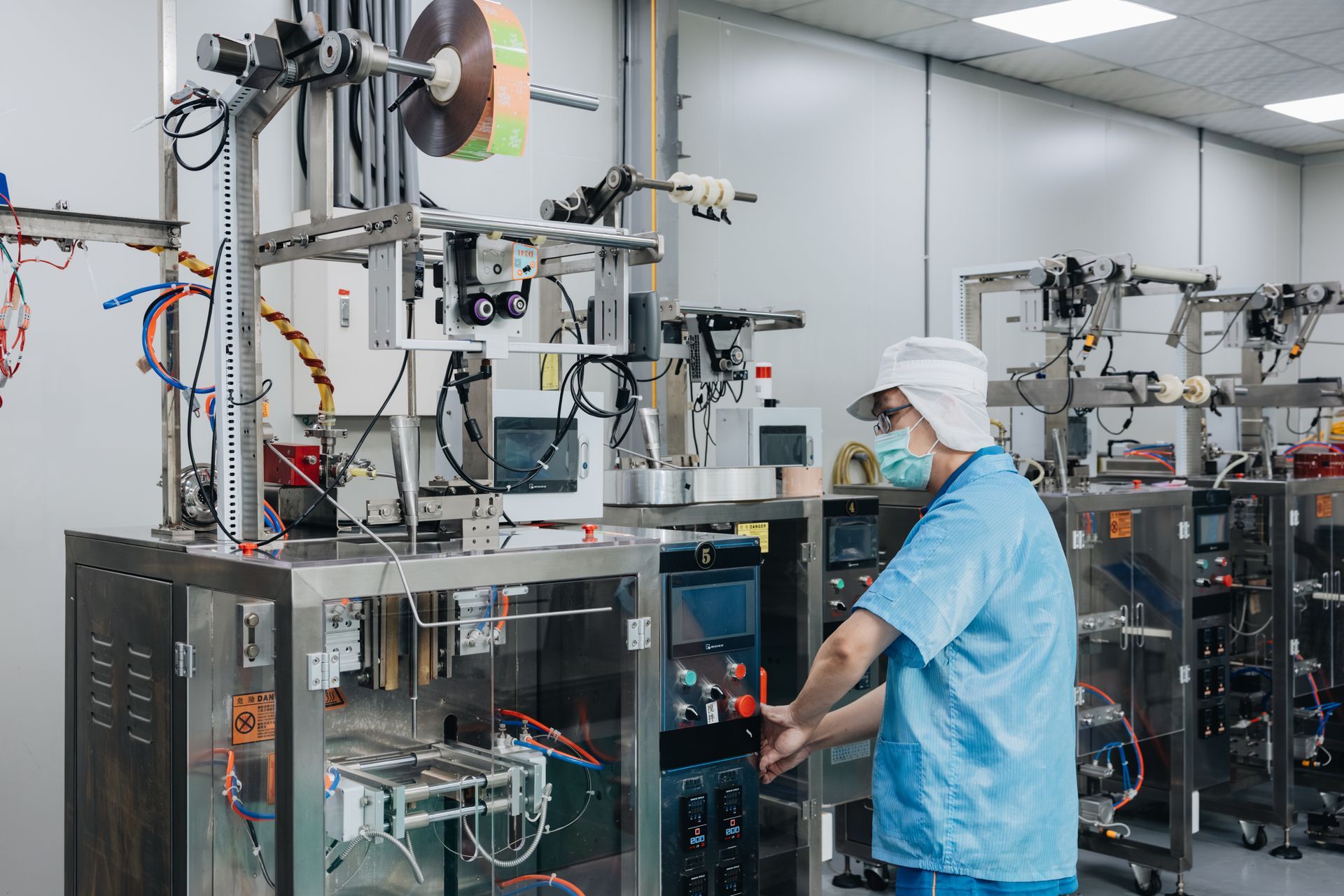 統荃生醫廠區技術人員操作背封式自動化隨身包充填機台。專精液體軟袋與隨身包代工充填，透過高精密高週波封口技術，落實防漏液品質控管與 MVP 敏捷開發測試。