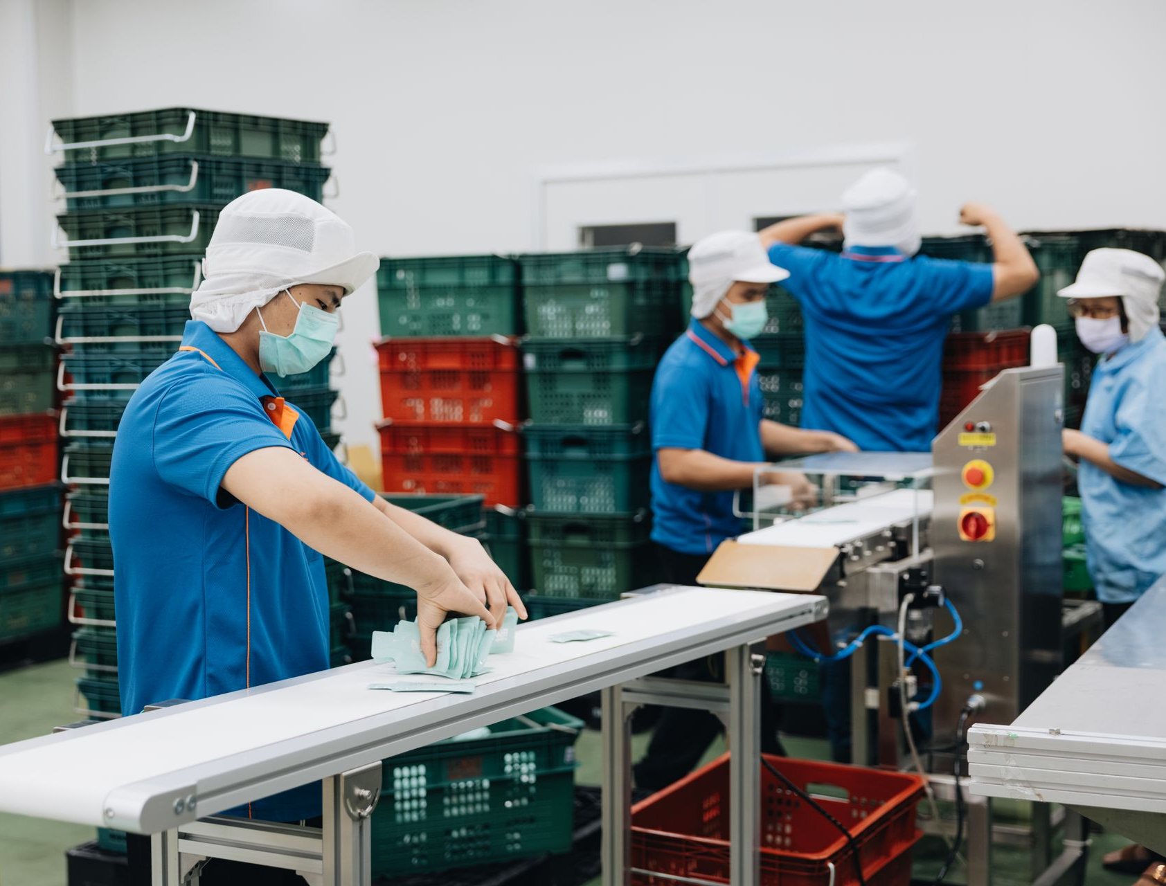 統荃生醫工作人員於自動化傳送帶進行隨身軟袋飲品之包裝與品管檢驗。提供透明一站式代工流程與少量試產方案,協助小老闆與新創電商快速下單上市。