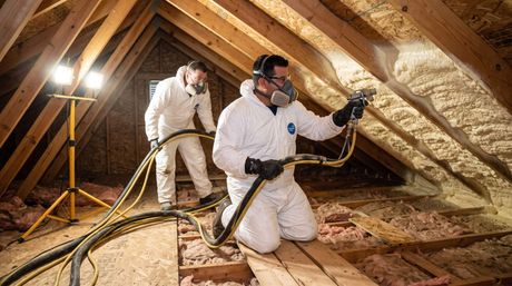 2 males applying spray foam insulation in attic