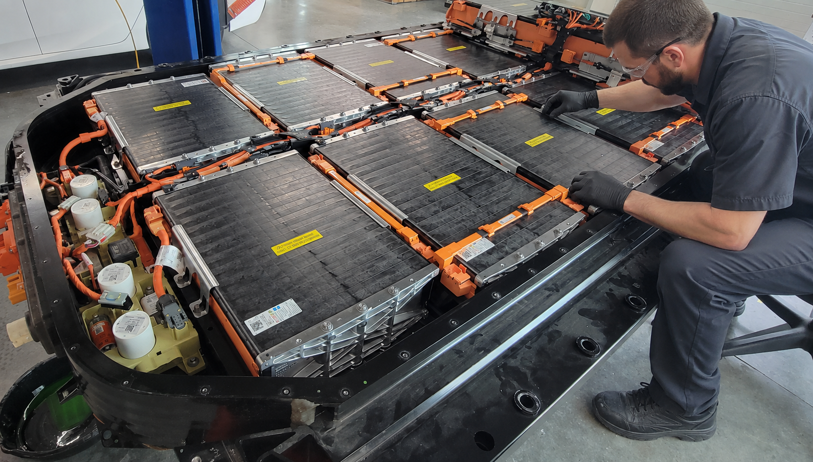 Technician inspecting electric vehicle battery components