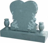 Gray heart-shaped gravestone with floral carvings and two small urns on a base