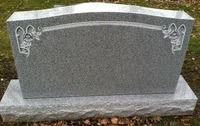 Gray granite gravestone with white angel carvings on both upper corners