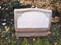 Blank gravestone plaque in a wooded cemetery setting