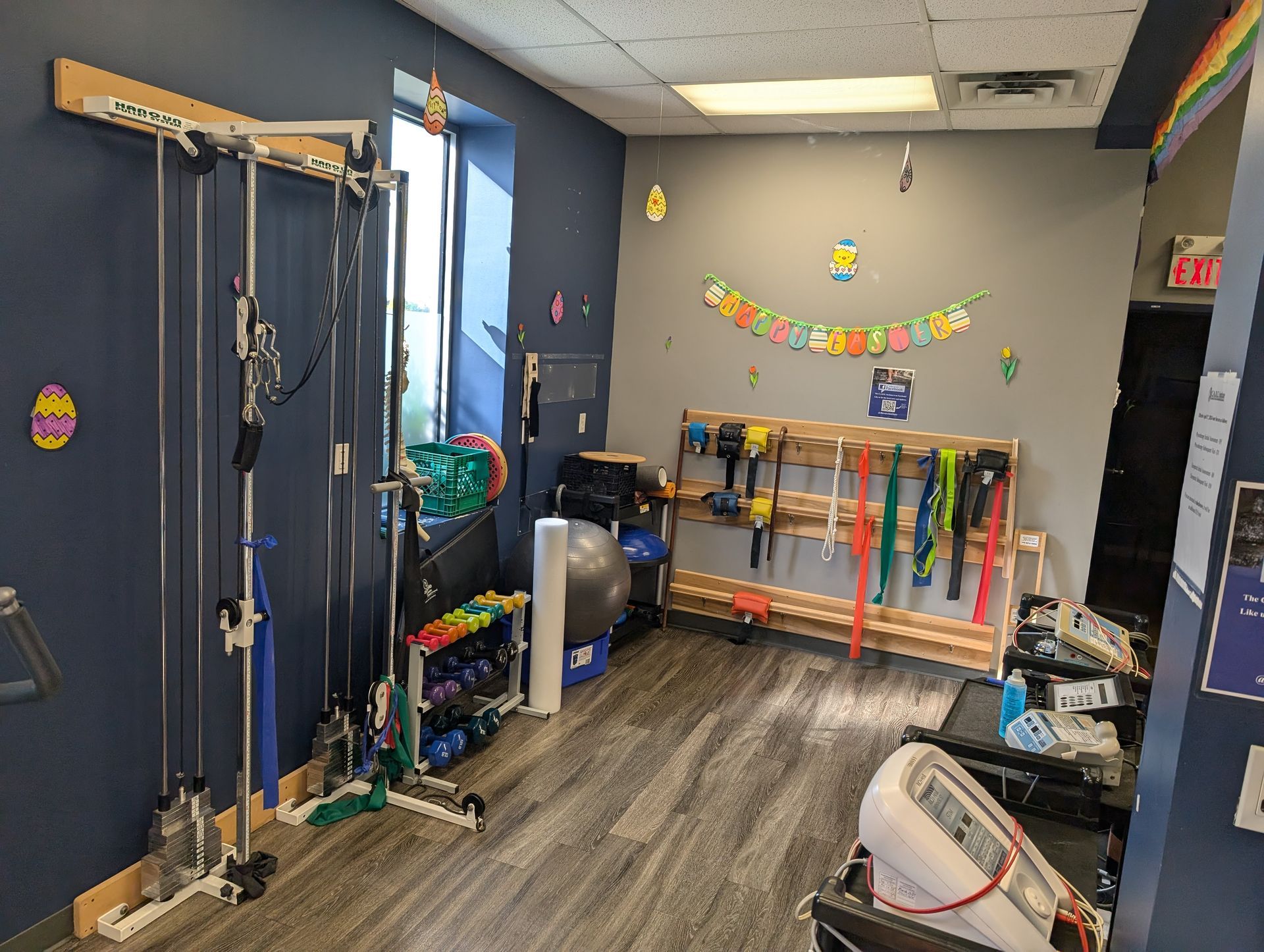 Kids' classroom or therapy room with lockers, bins, hanging straps, and colorful wall decorations