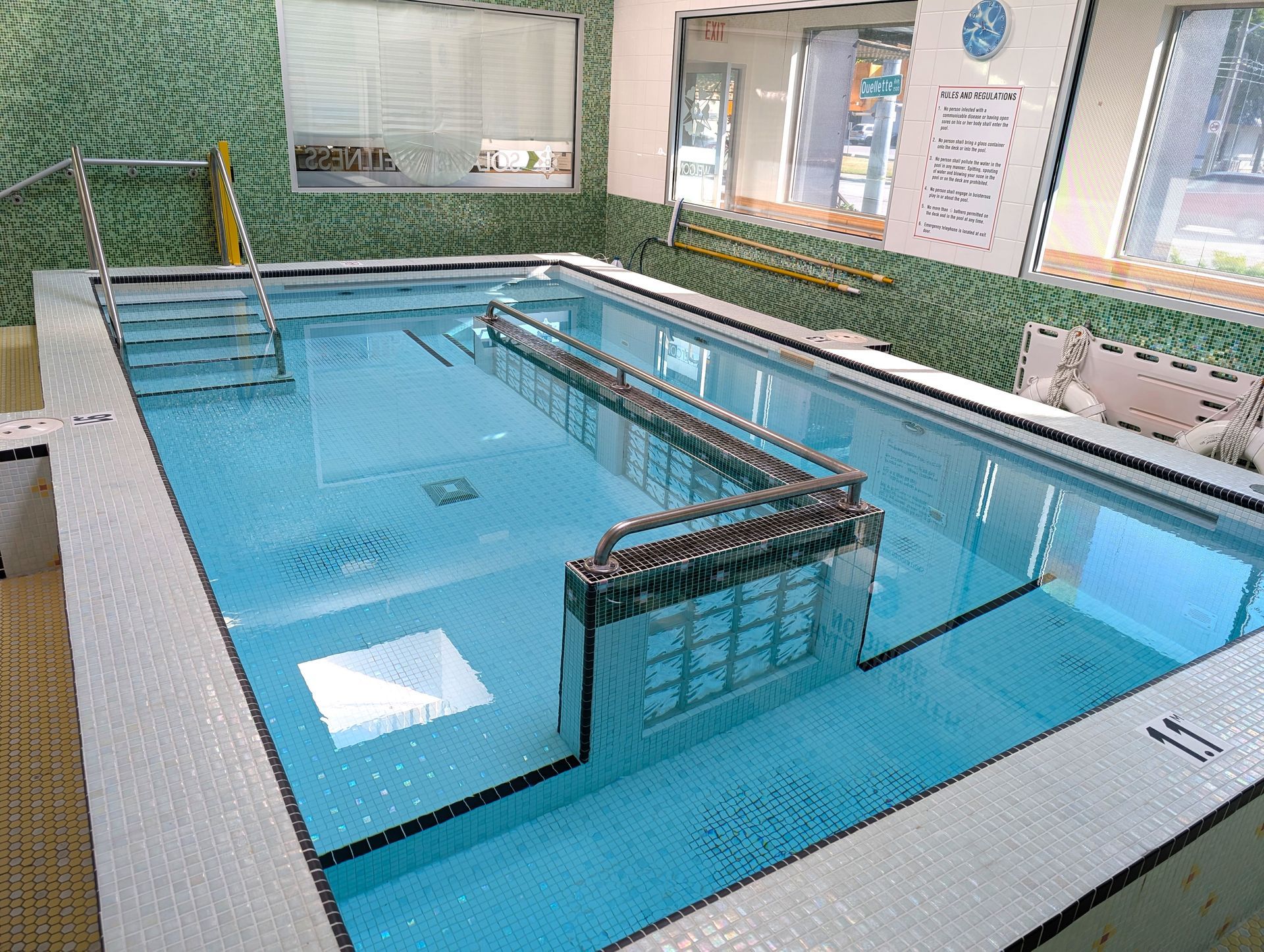 Indoor swimming pool with a central lane divider and blue water, viewed from above.