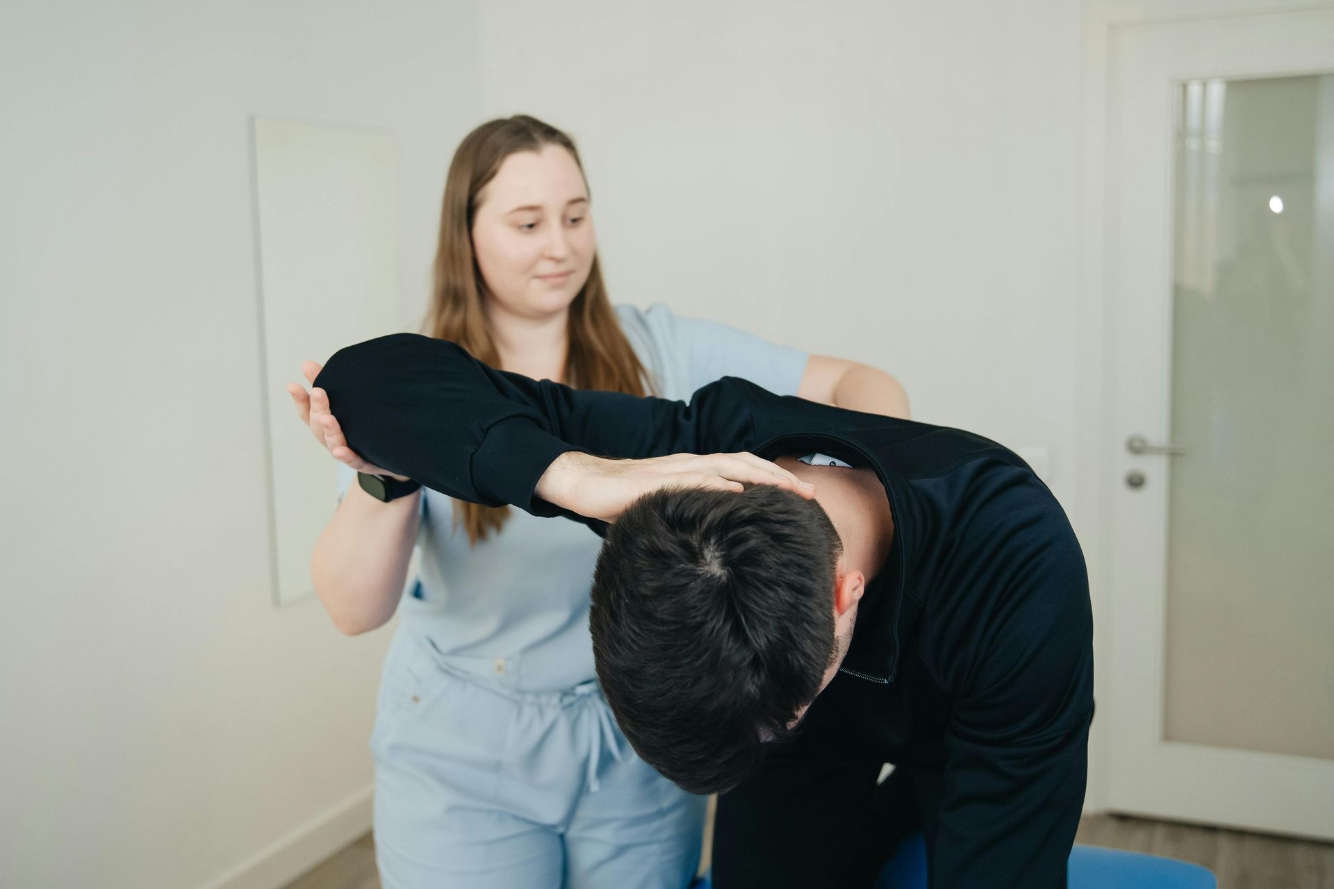 A woman is getting her wrist examined by a doctor.