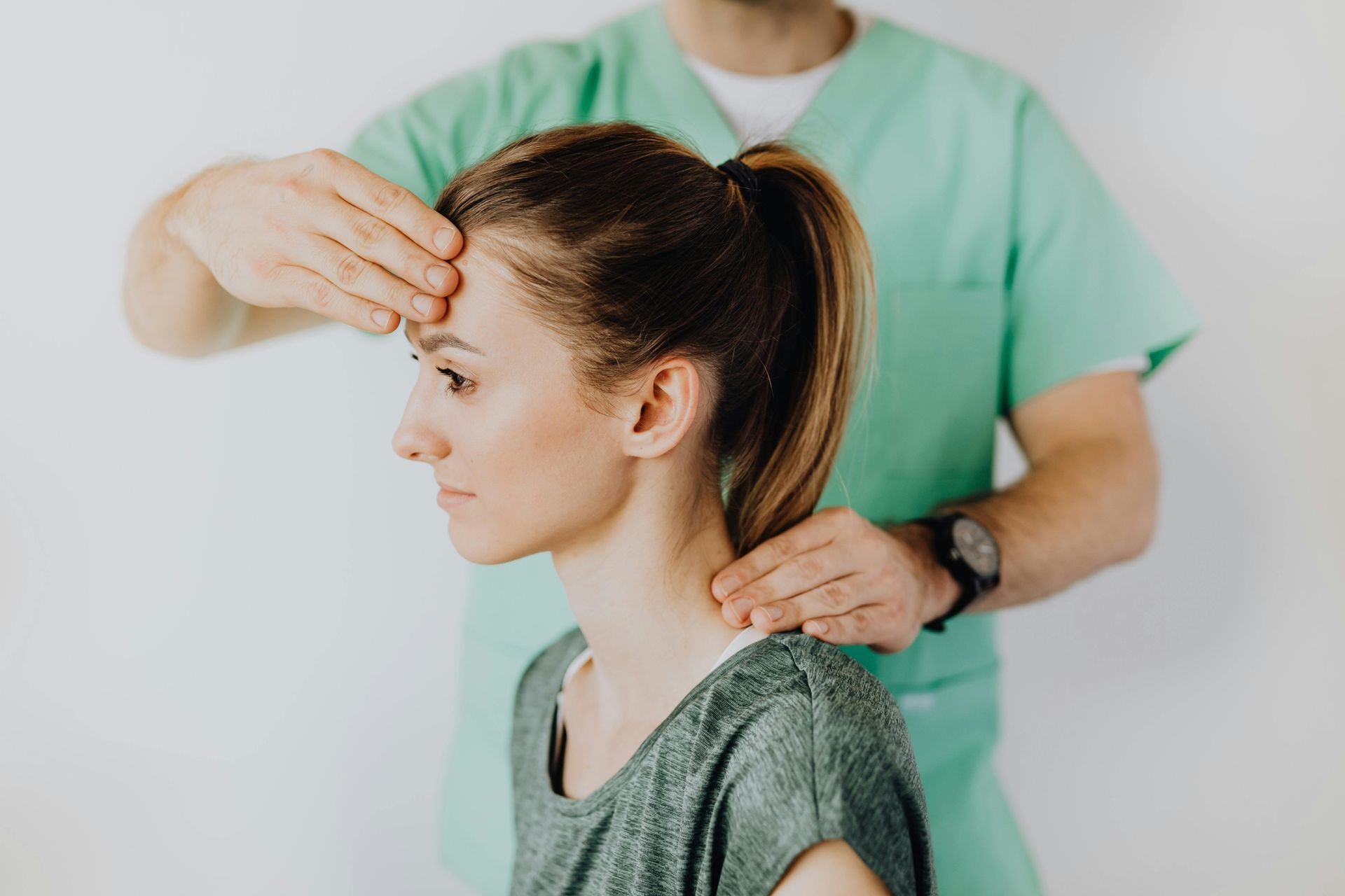 A woman is getting her wrist examined by a doctor.