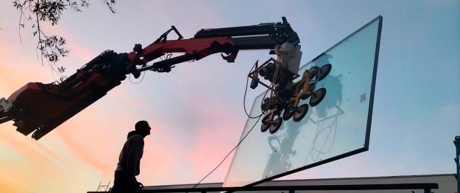 Una gru cinematografica in controluce riprende un ciclista sullo sfondo di un cielo rosa al tramonto.