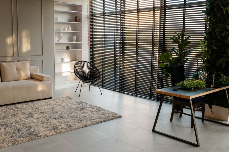 A living room with a couch , chair , table and blinds.