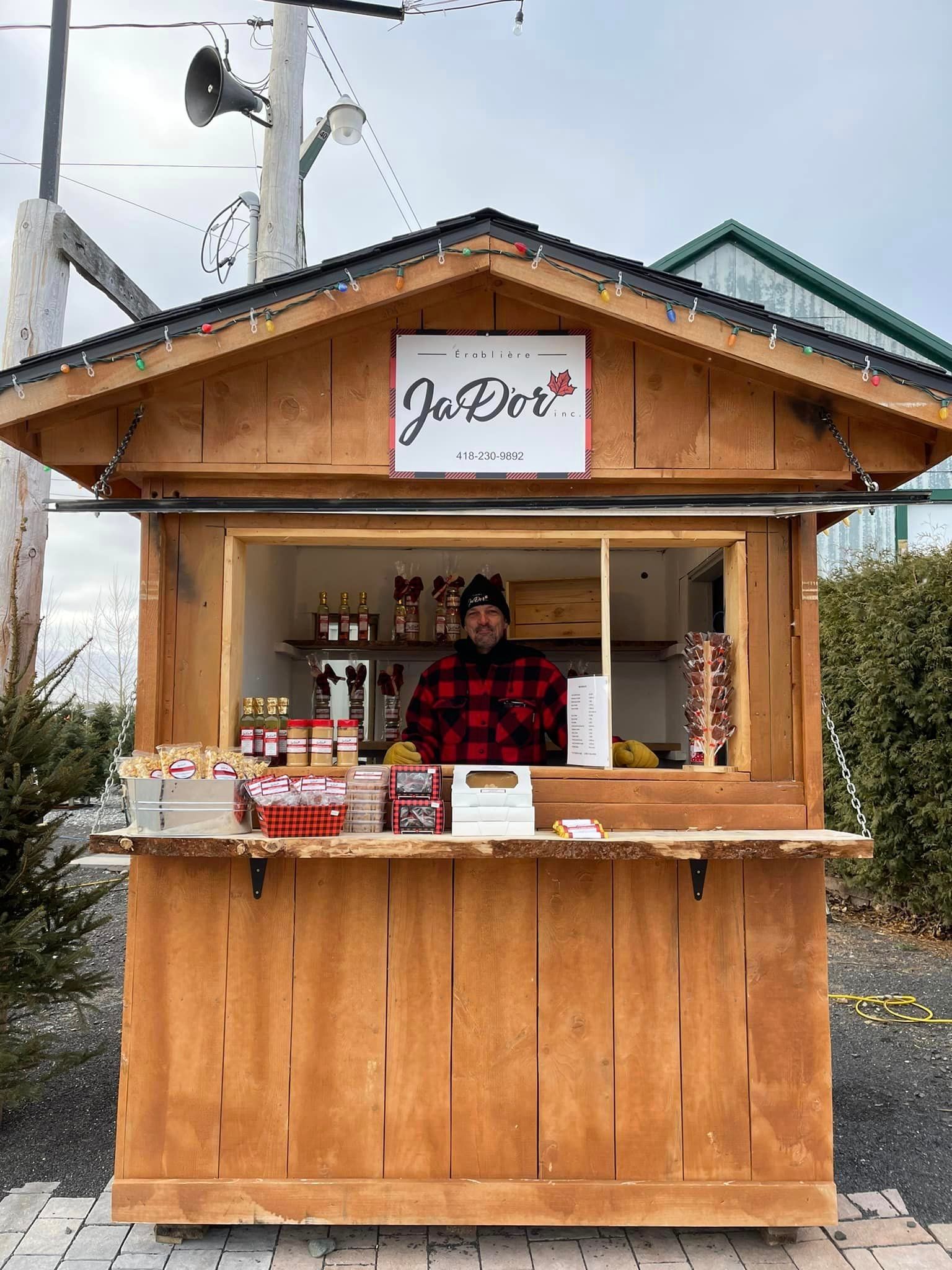 Un homme se tient devant un kiosque en bois.