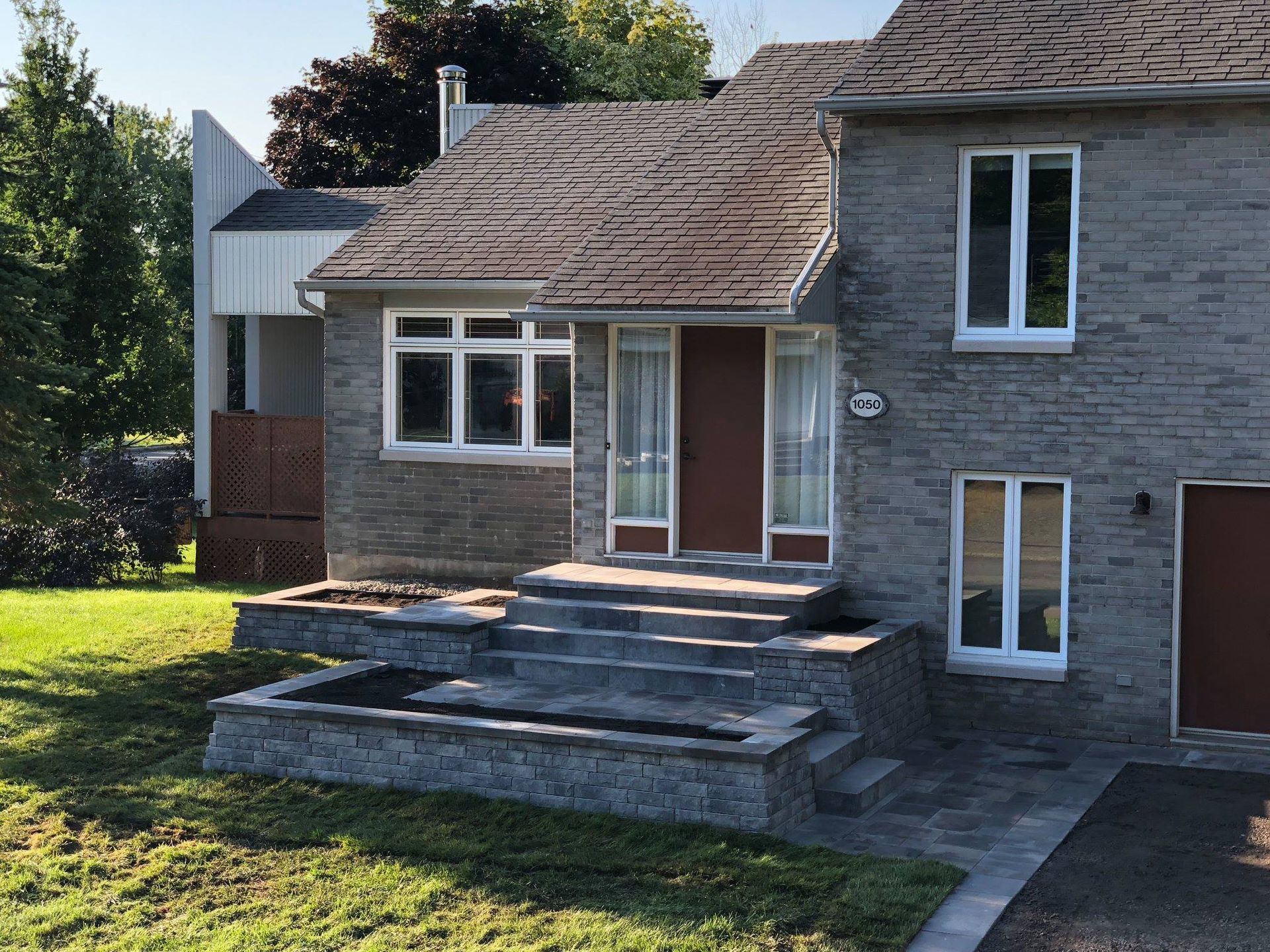 Une maison en briques avec des escaliers menant à la porte d'entrée