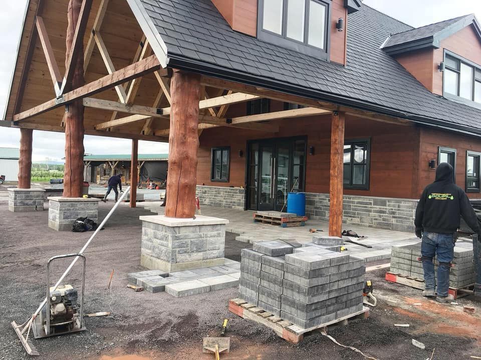 Un homme se tient devant une grande maison en construction.