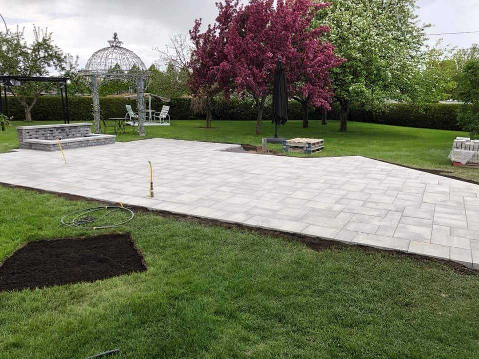 Un grand patio avec un belvédère en arrière-plan est en cours de construction dans une cour arrière.