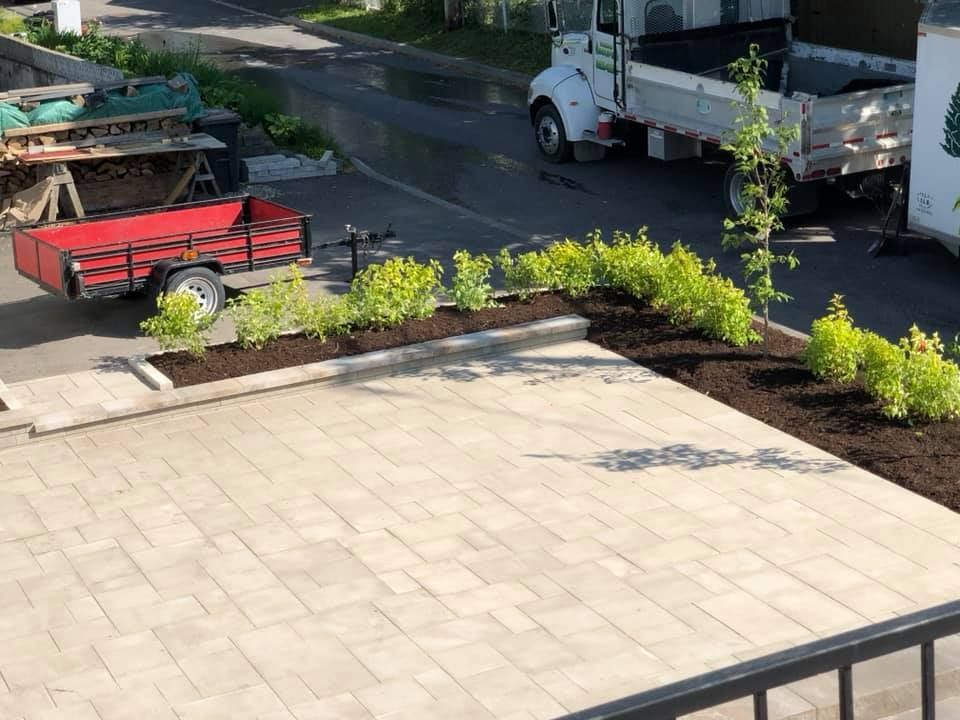 Une remorque rouge est garée dans une allée à côté d'un camion.