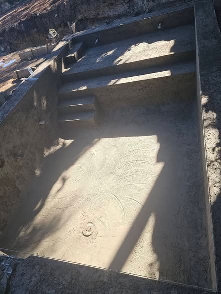 Concrete stairs leading down to a sunlit landing with railings and strong shadows