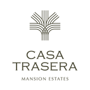 Logo for Casa Trasera Mansion Estates, featuring a stylized palm tree icon above the text in dark brown on a white background.