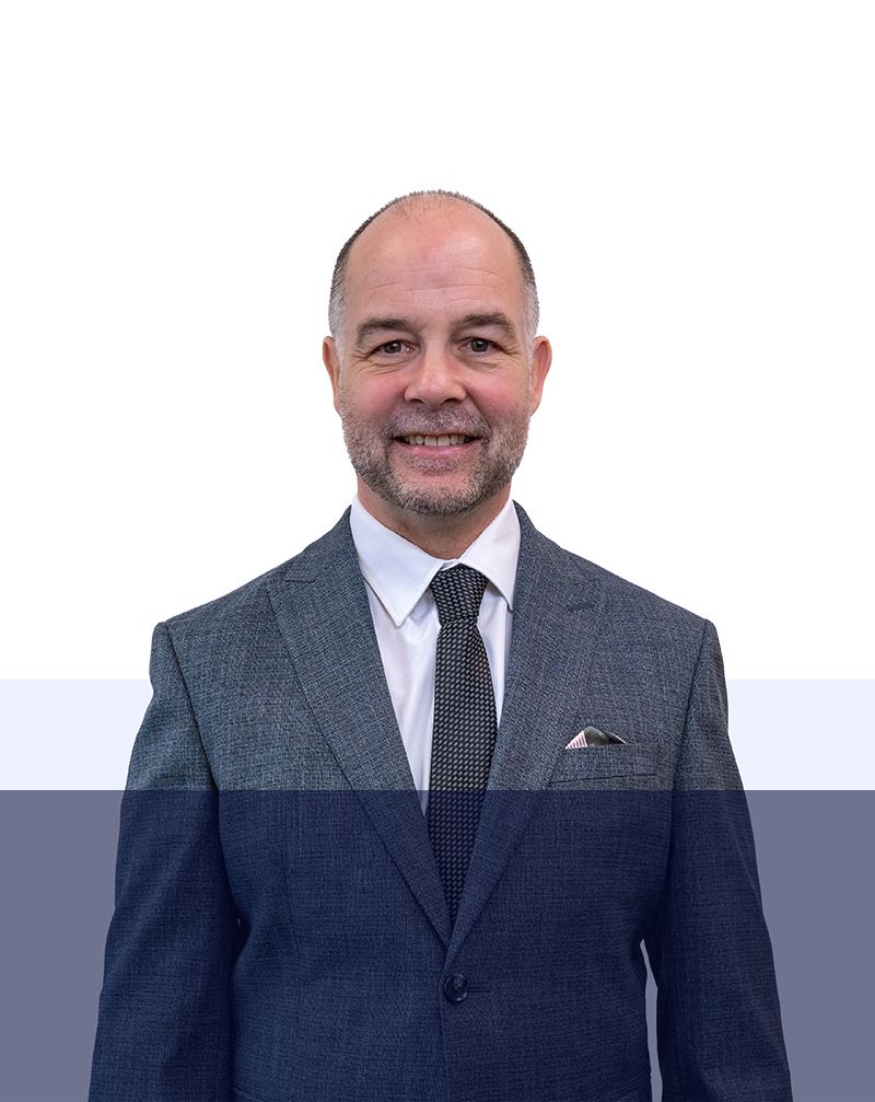 A man in a suit and tie is smiling for the camera.