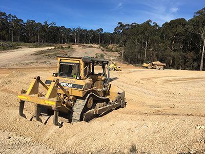 A bulldozer is driving down a dirt road.