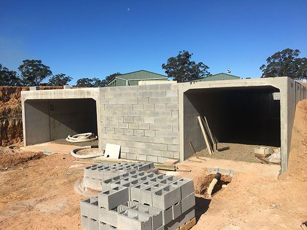 A stack of bricks is sitting in front of a building under construction.