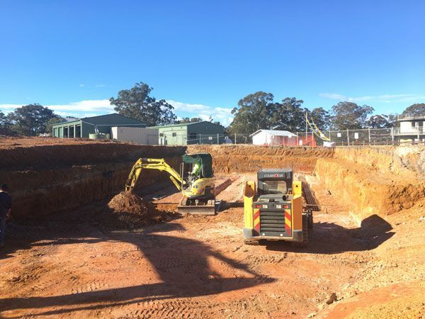 A group of construction vehicles are working on a construction site.