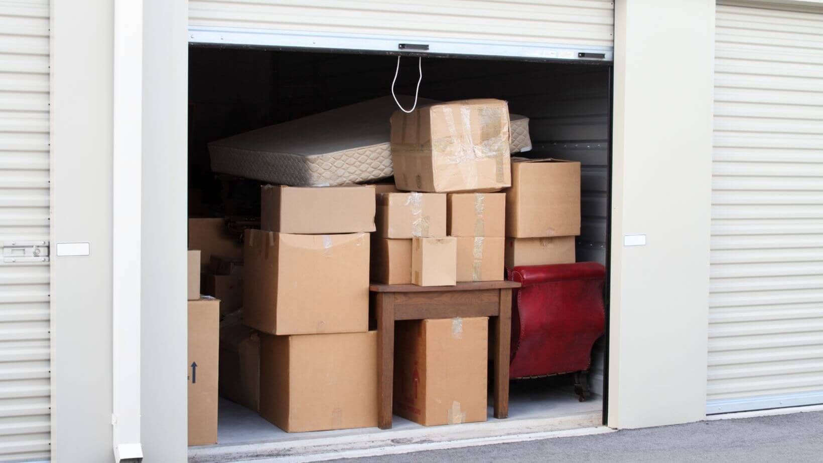 Warehouse interior with tall shelving packed with cardboard boxes.