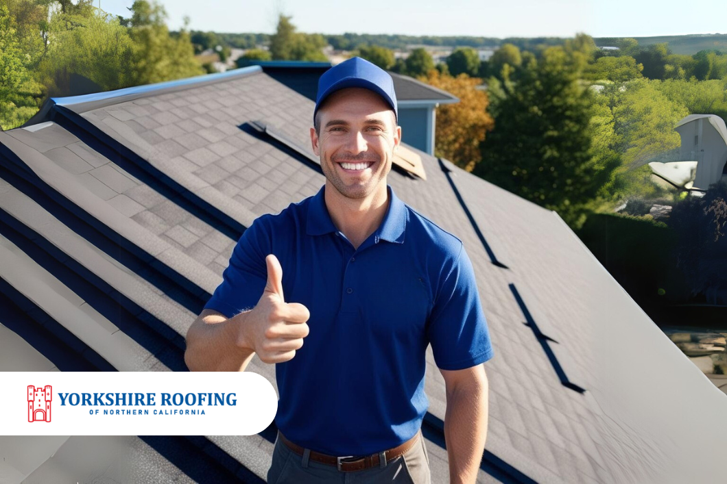 Smiling roofing worker in blue uniform giving thumbs up on a shingled roof, with company logo at bottom left