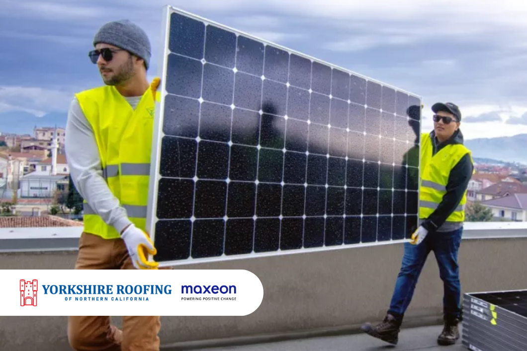 Workers carrying a large solar panel on a rooftop, wearing neon safety vests and winter hats