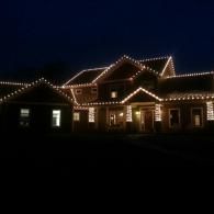 House outlined with white holiday lights at night