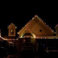 House decorated with white and colored Christmas lights at night