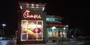Chick-fil-A restaurant at night with illuminated red sign and lit drive-thru area