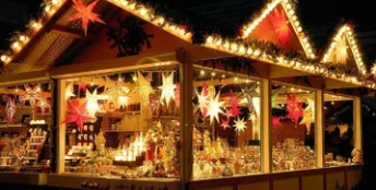 Festive Christmas market stall glowing with lights, ornaments, and holiday decorations at night