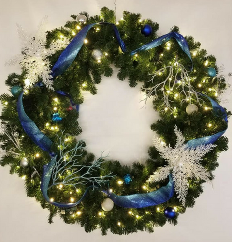 Decorated green holiday wreath with blue ribbon, white snowflakes, and gold-blue ornaments