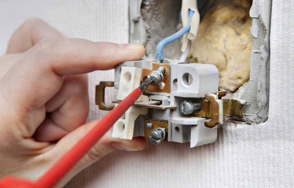 Hand Using Screwdriver on Electrical Outlet — Rohr Electrical in Narromine, NSW