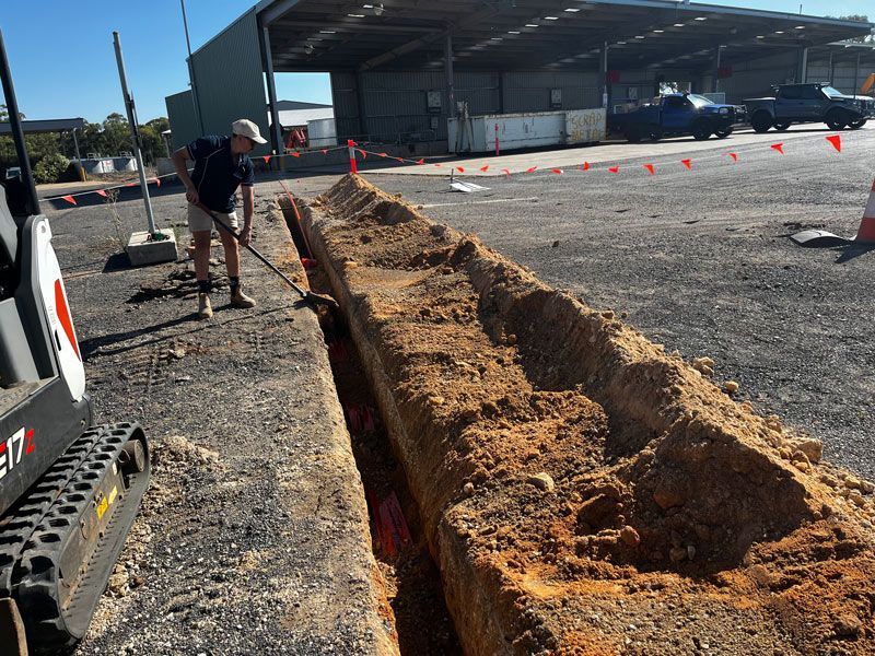 Man Digging For Laying The Electrical Wiring Underground — Rohr Electrical in Dubbo, NSW