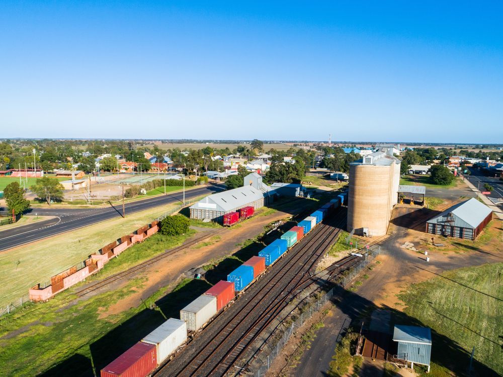 Train With Colorful Containers Next to Silos and Buildings — Rohr Electrical in Narromine, NSW