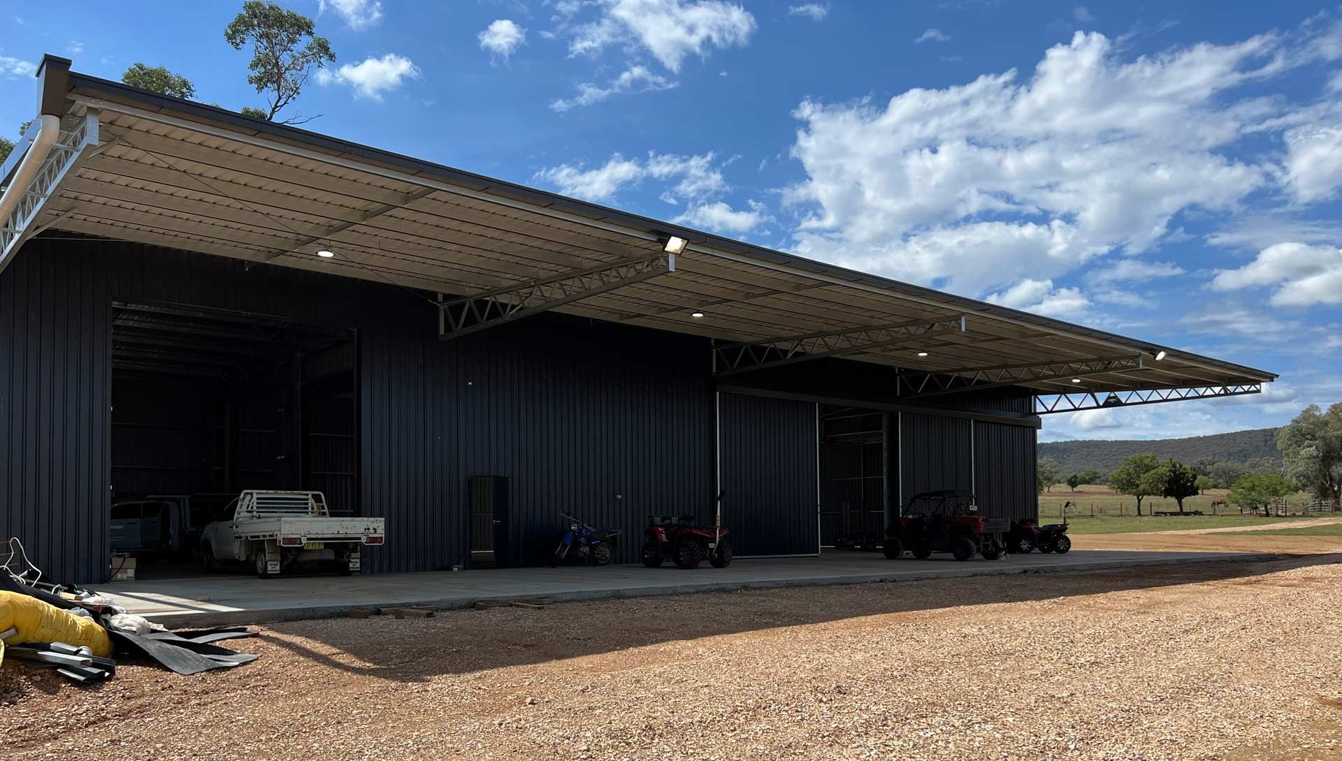 Dark Metal Building With a Partially Open Roof — Rohr Electrical in Dubbo, NSW