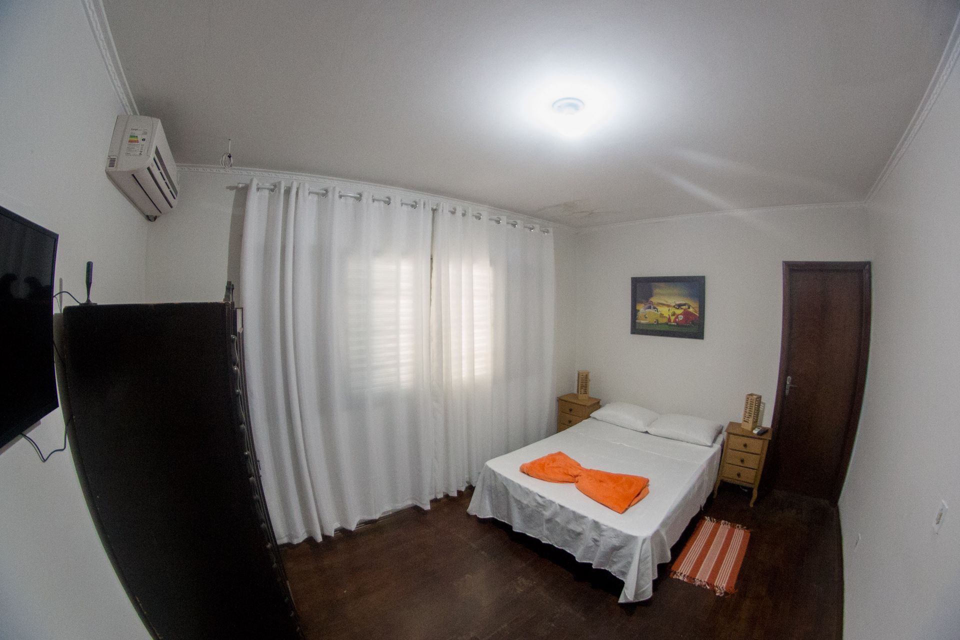 Um quarto com uma cama e uma televisão na parede