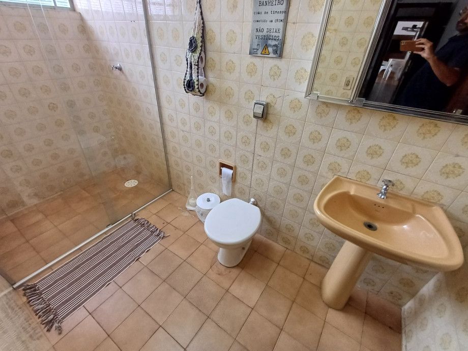 Um banheiro com vaso sanitário, pia e chuveiro.