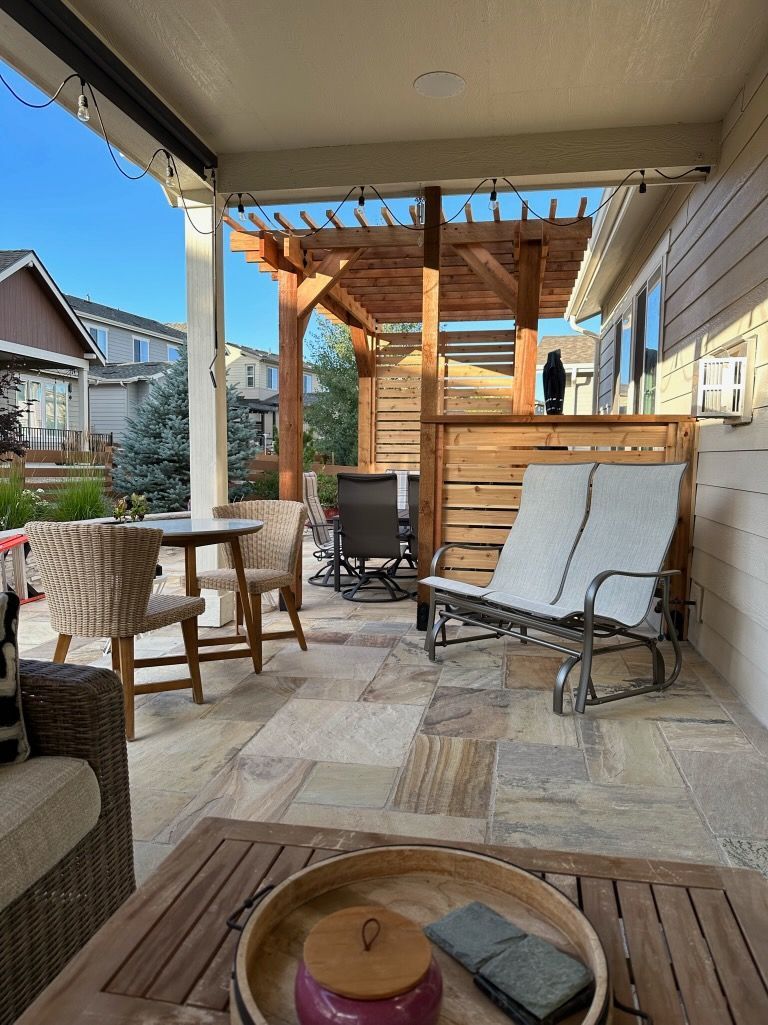 A patio with a table , chairs , and a pergola.
