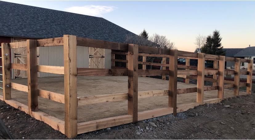 A wooden fence is sitting in front of a house.