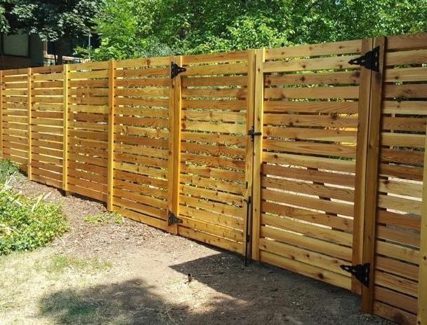 A wooden fence with a gate in the backyard