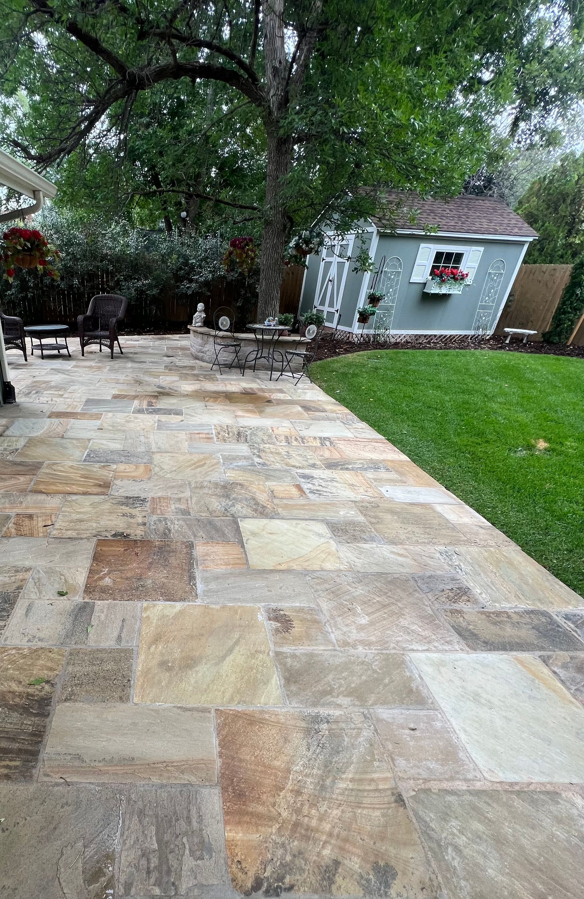 A stone walkway leading to a shed in a backyard.