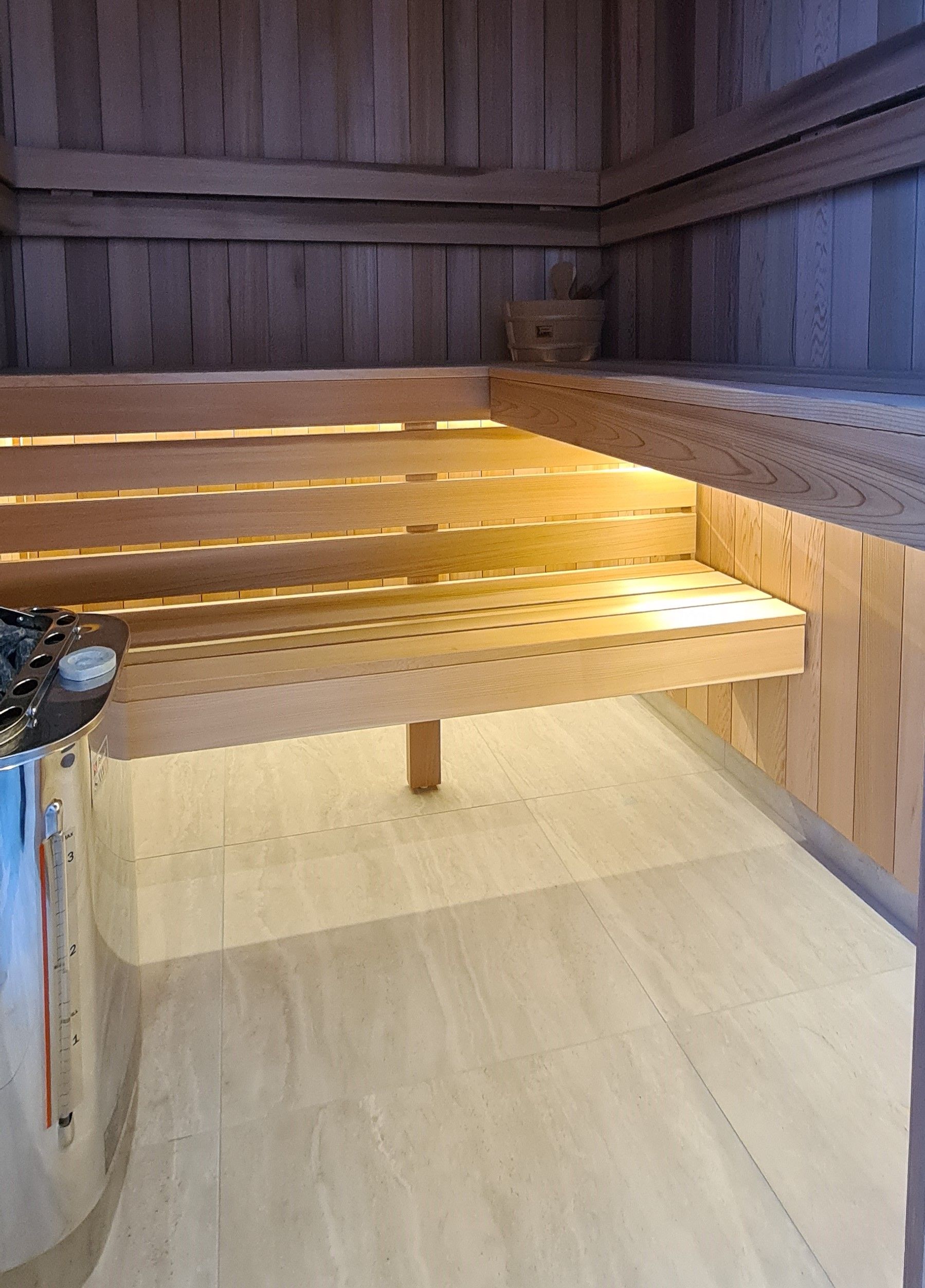 Wooden sauna bench with built-in warm lighting in a wood-paneled room
