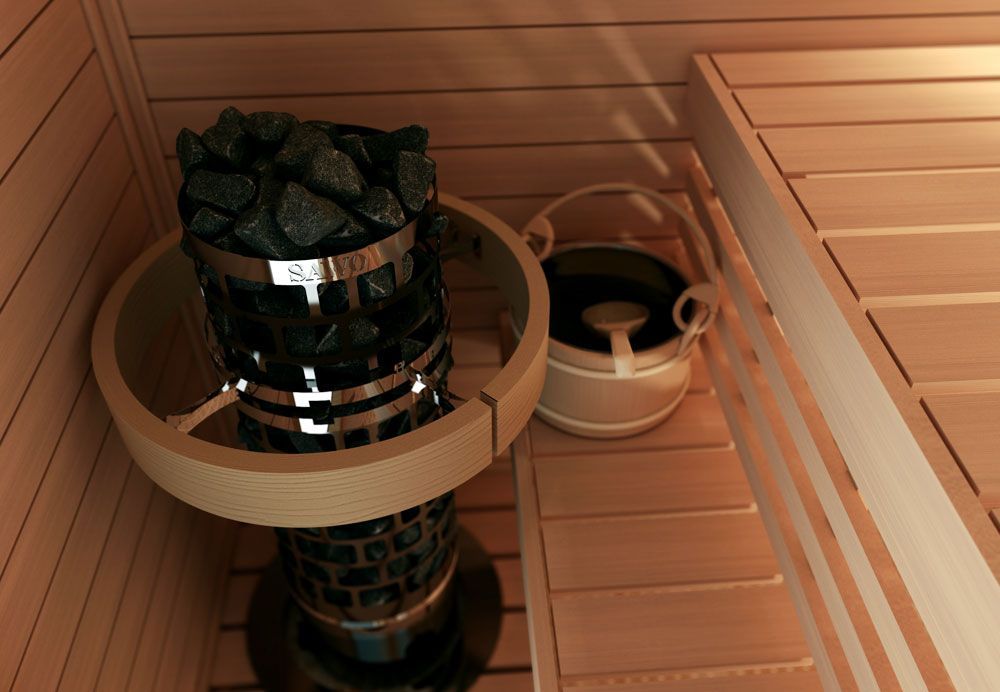 Sauna heater with rocks and a wooden bucket in a wood-paneled sauna interior