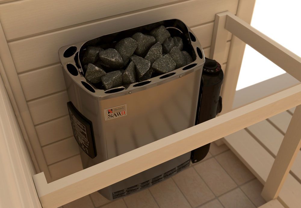 Sauna heater with dark stones beside a wooden railing in a tiled room